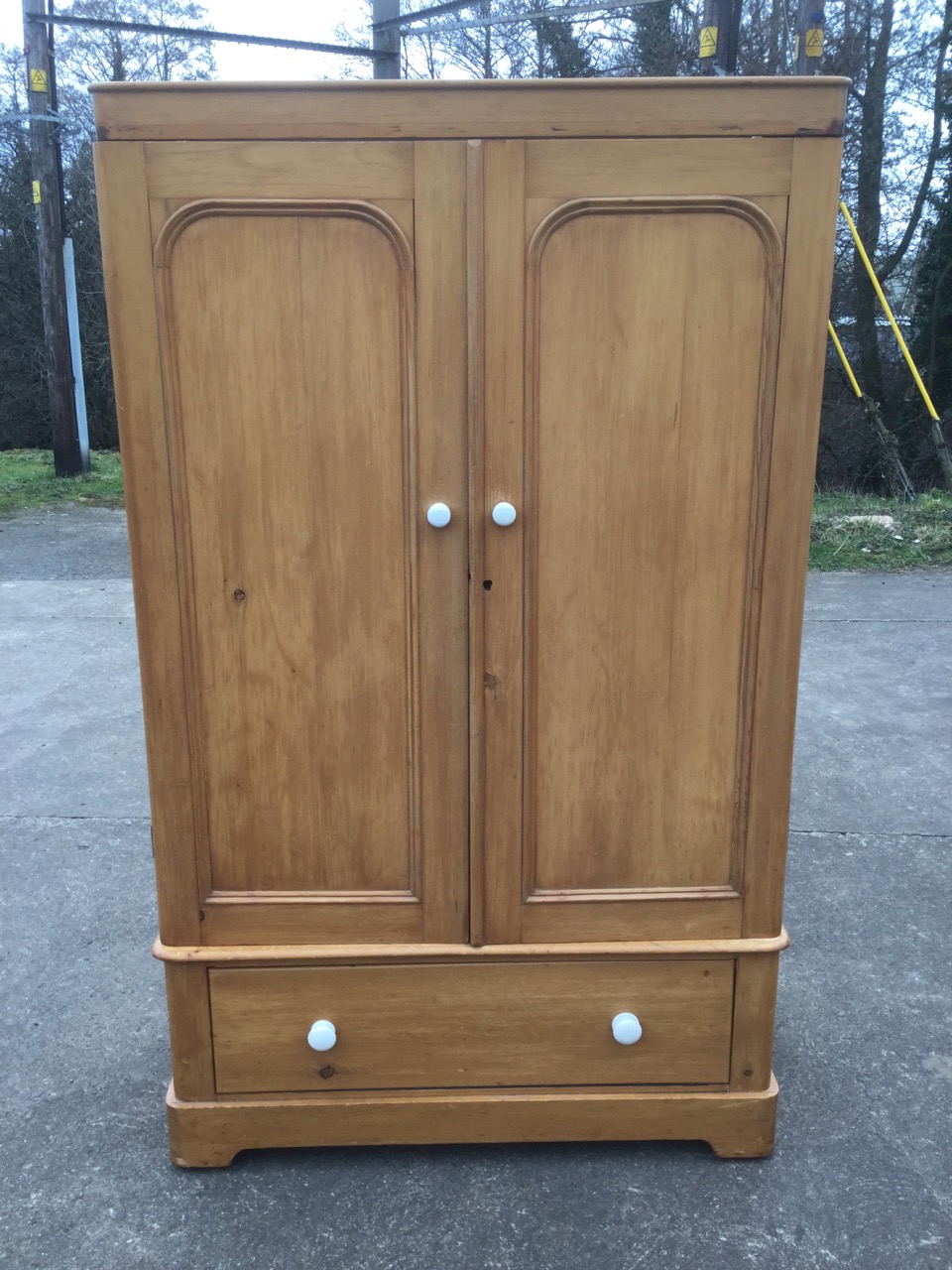 A Victorian pine wardrobe, having plain cornice above a pair of arched panelled doors mounted with