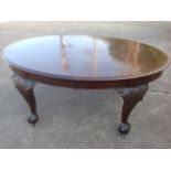 A late nineteenth century extending mahogany dining table, the moulded top with two spare leaves