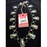 A contemporary silver necklace, with tapering panels of elliptical cabochon beads linked by chain