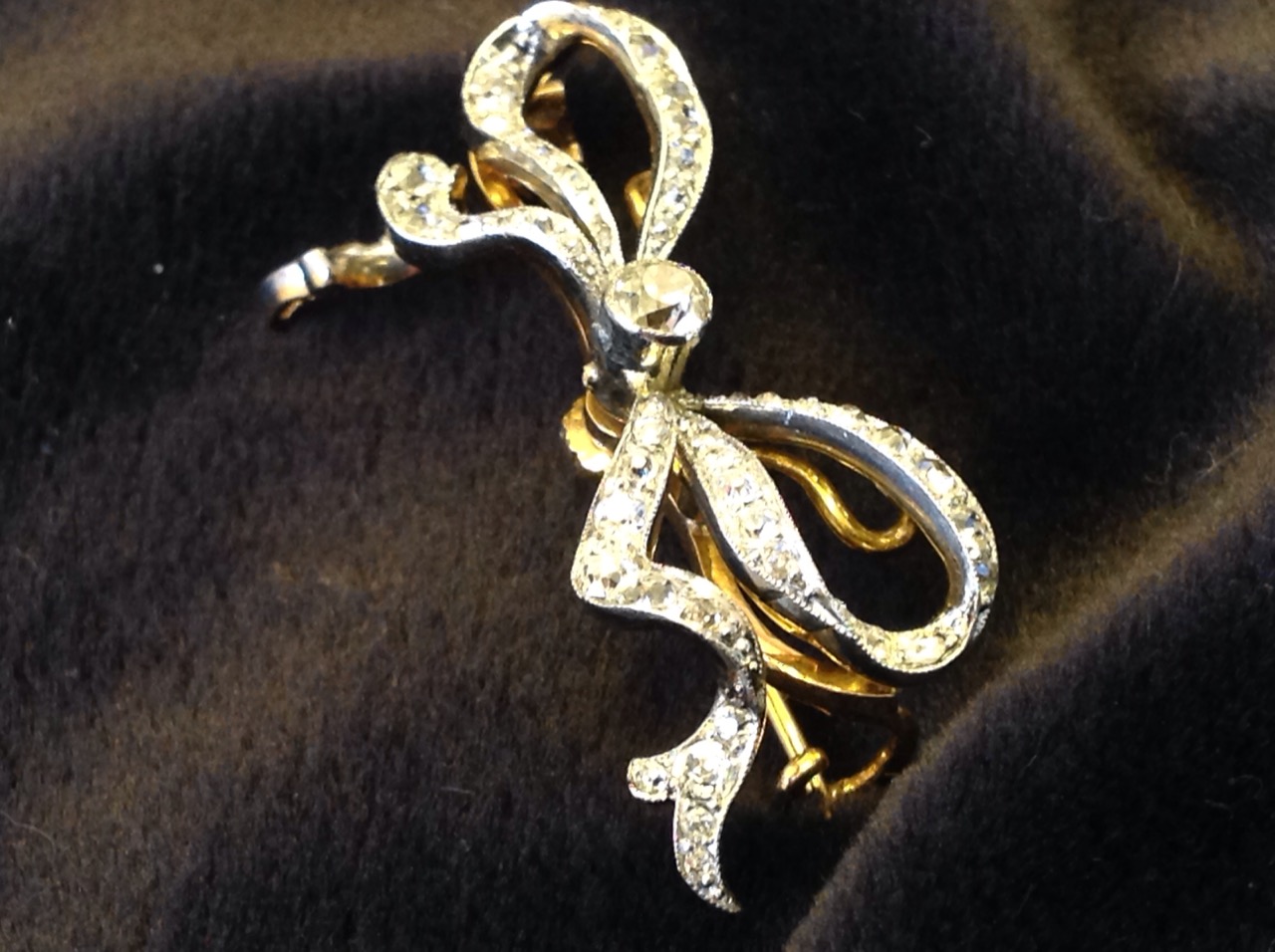 An 18ct gold diamond bow brooch, the ribbon bands set with diamonds around a central brilliant cut - Image 3 of 3