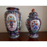 A Cantonese Imari style lidded jar with matching tapering vase, decorated with floral panels of