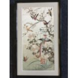 A framed Chinese silk embroidered panel depicting birds and butterfly in blossom foliage,