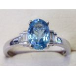 An 18 carat hallmarked gold aquamarine & diamond ring, the claw set oval aquamarine stone above
