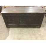 A large eighteenth century oak coffer, the moulded hinged lid above a panelled box, the three