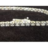 A fine 18ct diamond tennis bracelet, with fifty-six hinged claw set diamonds weighing over one-and-