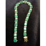 An 18ct yellow gold emerald & diamond bracelet, with twenty one claw set emeralds of approx 15