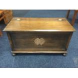 A stained oak blanket box with moulded hinged lid and panelled box carved with gilded motif,