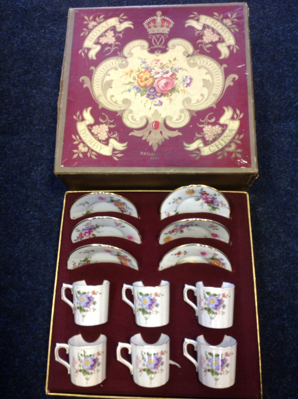 A boxed Royal Crown Derby six-piece teaset, the cups and saucers with gilt rims decorated in the