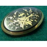 A boxed Victorian oval gold inlaid tortoiseshell brooch, depicting stylised foliate bird in nest,
