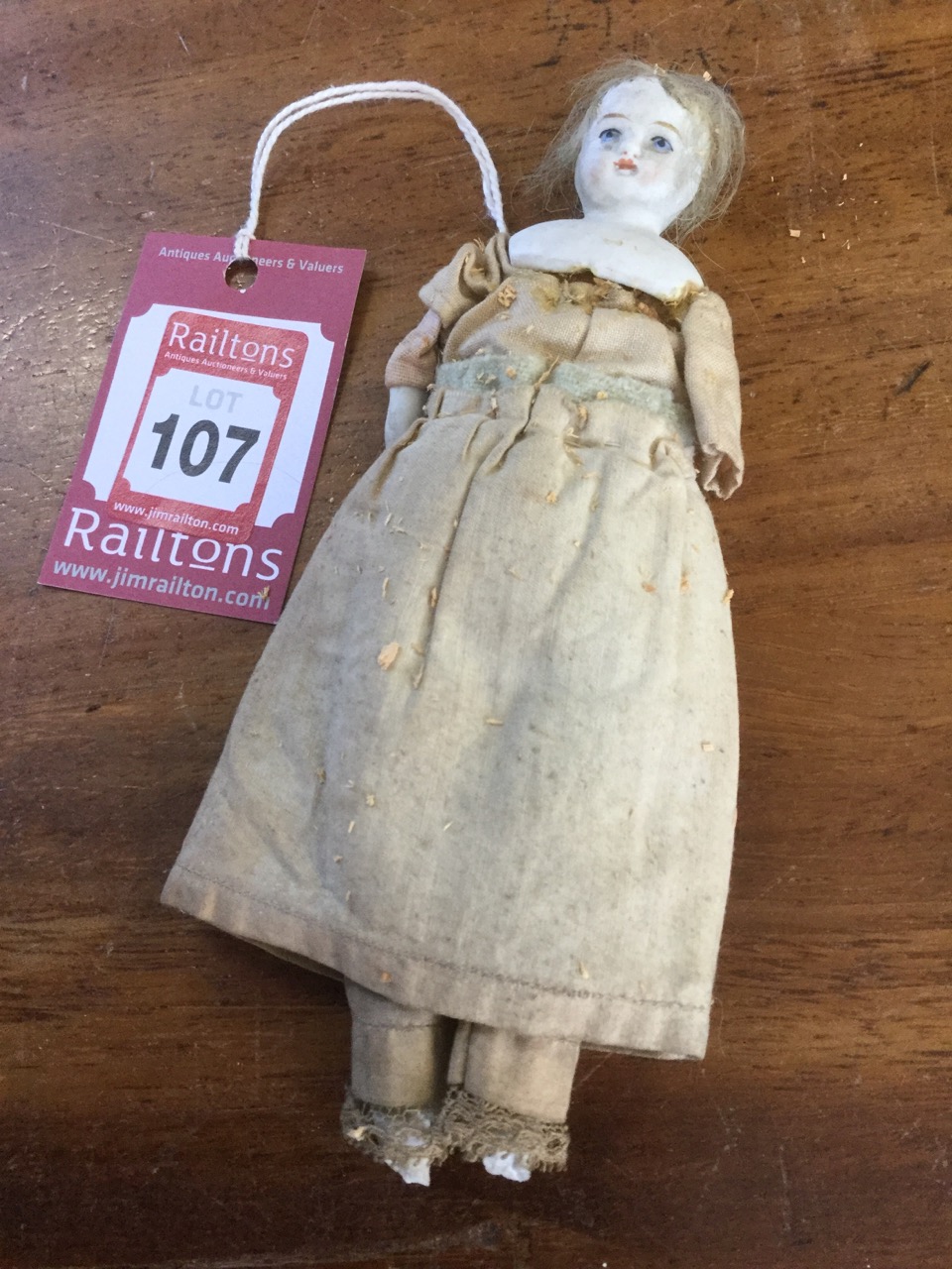 An early nineteenth century doll, with hand-painted porcelain head on sawdust stuffed body,