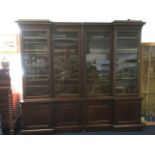 A nineteenth century oak inverted breakfront bookcase, with moulded cornice above four glazed