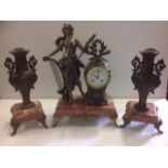 An art nouveau French clock garniture, the central timepiece with maiden holding harp aside a clock,