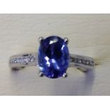 An 18ct gold oval tanzanite and diamond ring, the claw set tanzanite stone of over 1.5 carats,