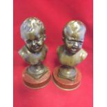 A pair of nineteenth century bronze boys, the busts crying & laughing, on socle mounted on