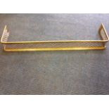 A nineteenth century brass fender, with pierced diamond shaped grill beneath a tubular rail,