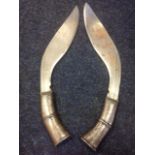 A pair of nineteenth century kukri knives, the curved channelled blades with niello decoration to