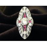 A large platinum ruby & diamond dress ring, the pierced elliptical panel set with diamonds around