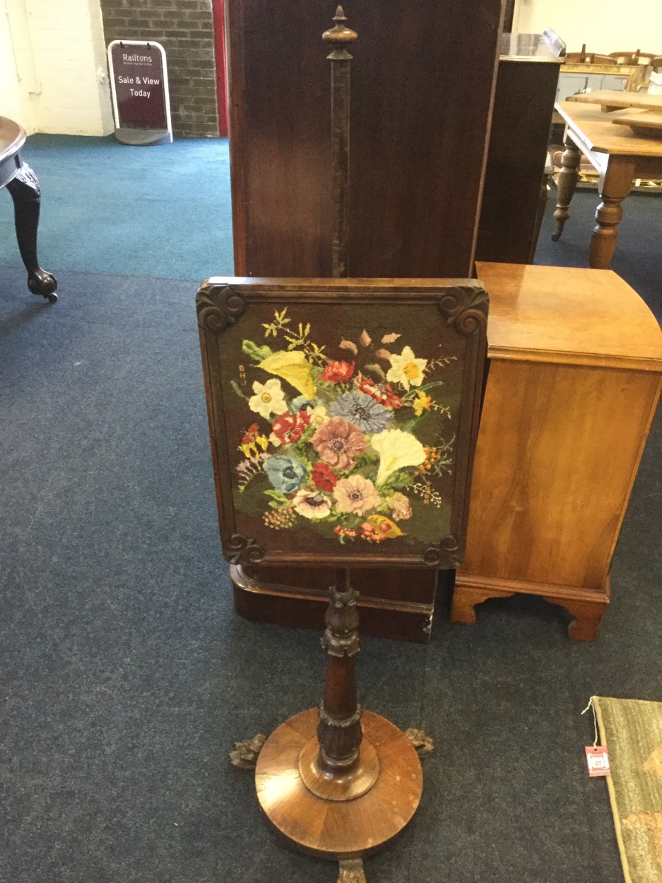 A George IV rosewood pole screen, with floral needlework panel in moulded frame having scroll carved