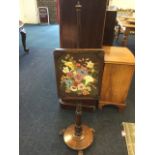 A George IV rosewood pole screen, with floral needlework panel in moulded frame having scroll carved