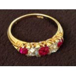 An 18 carat gold hallmarked ruby & diamond ring, the five stones claw set in the band, the rubies of