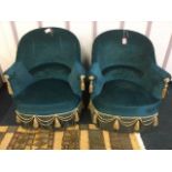 A pair of upholstered deco saloon chairs, with tub shaped padded backs above sprung seats