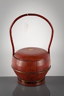 A Chinese red lacquered wood carrier and cover, with brass band mounts beneath a cane loop