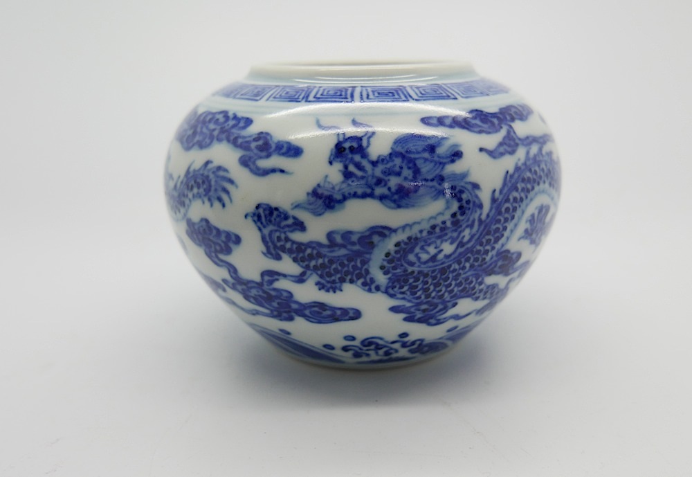 A Chinese blue & white jar decorated with five-clawed dragons and clouds beneath greek key band -