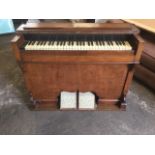A Victorian walnut case harmonium, with five octave keyboard and twin pedals driving bellows, the