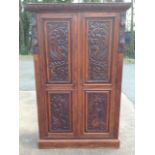 A Victorian carved oak wardrobe, the leaf cornice above twin panelled doors depicting gryphons and