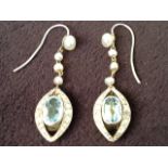 A pair of 18 carat gold drop earrings, the aquamarine oval stones of 1.38 carats framed by