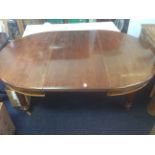 A Victorian walnut dining table with telescopic action and spare leaf, the moulded top supported