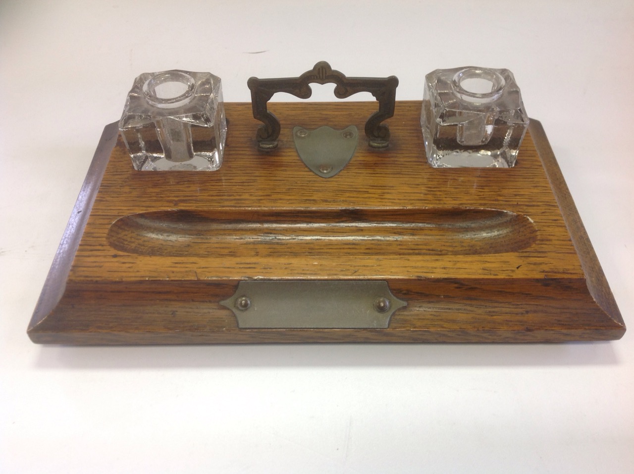 An Edwardian oak desk tidy, the moulded rectangular stand on bun feet, fitted with twin glass