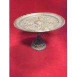 A nineteenth century bronze comport, the plate embossed with classical battle scene around a