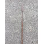 A tribal spear, the stick fitted with wrought iron terminal having sharp tapering leaf shaped blade.