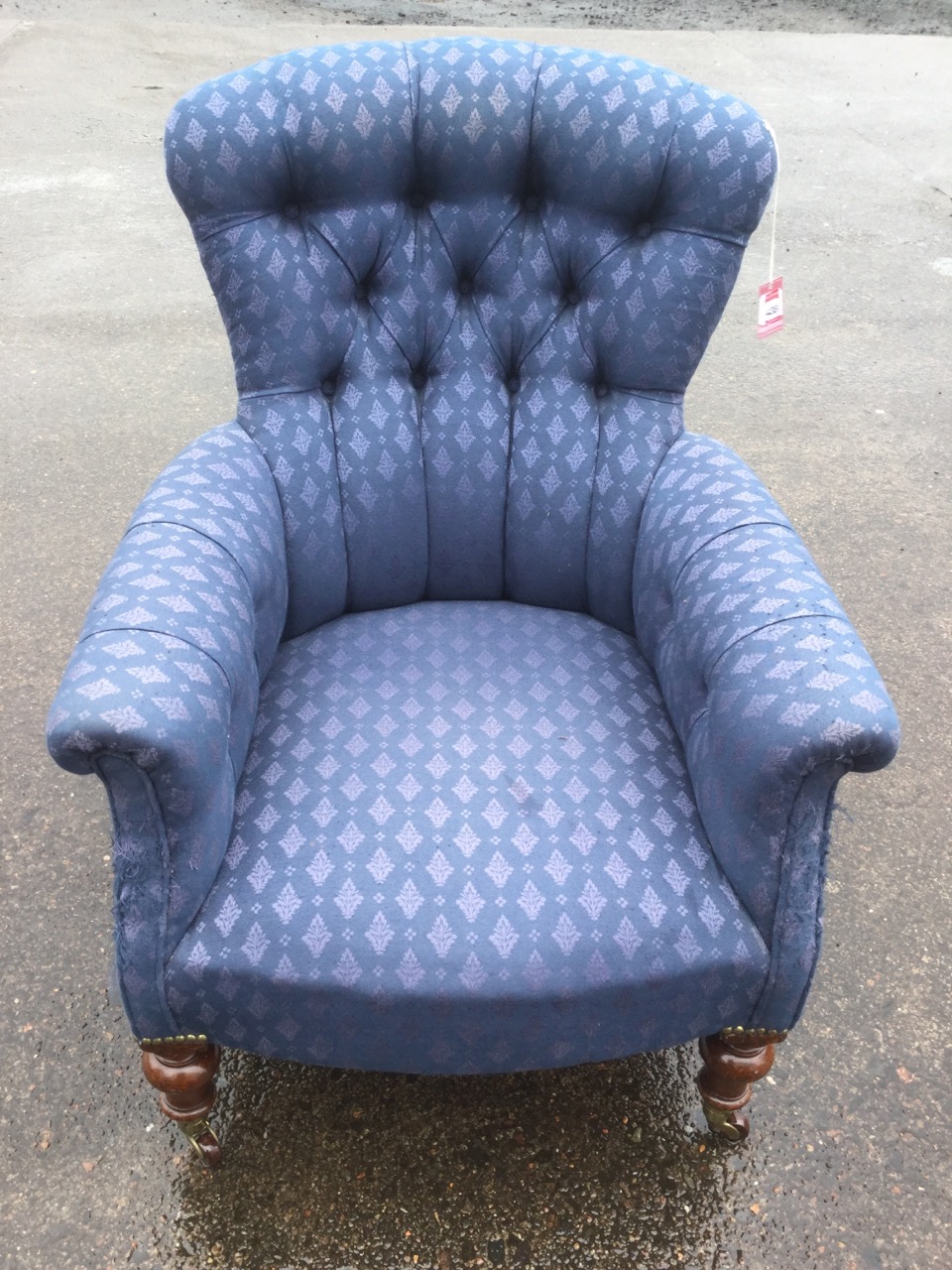 A Victorian spoonback armchair, with button upholstery and padded arms, raised on turned legs with