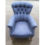 A Victorian spoonback armchair, with button upholstery and padded arms, raised on turned legs with