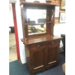 An art nouveau walnut sideboard, with overhanging cornice on pierced supports above a bevelled