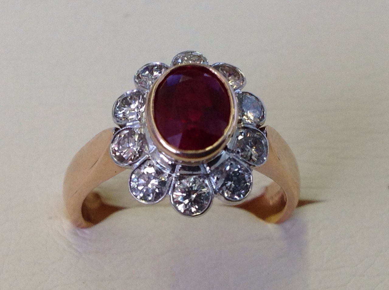 A hallmarked 18ct rose gold ruby & diamond ring, the oval bezel set ruby of over one-and-a-half