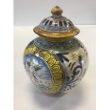 A majolica urn & cover with button finial to lid, the pot decorated with scrolled panel of a