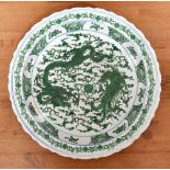 A large Chinese charger with scalloped rim decorated with green glazed dragons and phoenix in