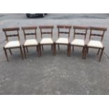 A set of six Victorian mahogany dining chairs, having plain backs above carved joining rails, with