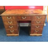 A Chippendale style nineteenth century kneehole desk, having tan leather gilt tooled skiver above