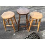 A pair of beech kitchen stools, with circular seats raised on angled turned legs; and another