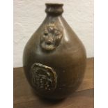 A Bellarmine stoneware jar of ovoid form mounted with handle having moulded rim, the body with