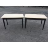 A pair of painted formica topped tables, the rectangular platforms supported on square tapering