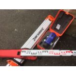 A Silverline boxed surveyors level, complete with tripod telescopic stand and calibrated staff -