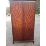 A Stag mahogany twin-door wardrobe, mounted with brass ring handles, raised on bracket feet.