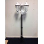 A contemporary garden light, the fluted tapering black post supporting three scrolled branches