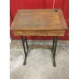 A childs oak school desk, the cleated angled top below a pen groove and inkwell hole, supported on a