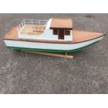 A 4ft model cabin cruiser, the wood boat having painted hull, mounted on stand.